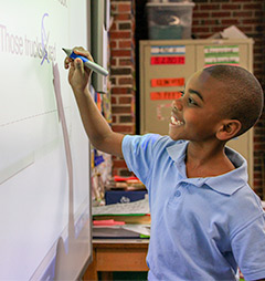 student working on an interactive whiteboard